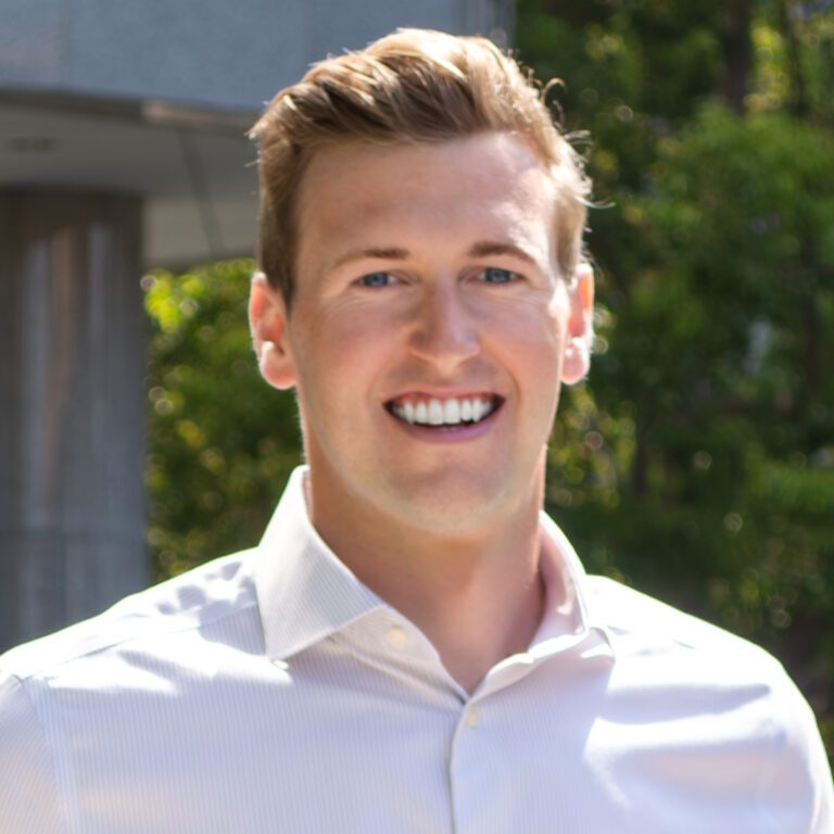 Headshot of man with blonde hair and a white shirt