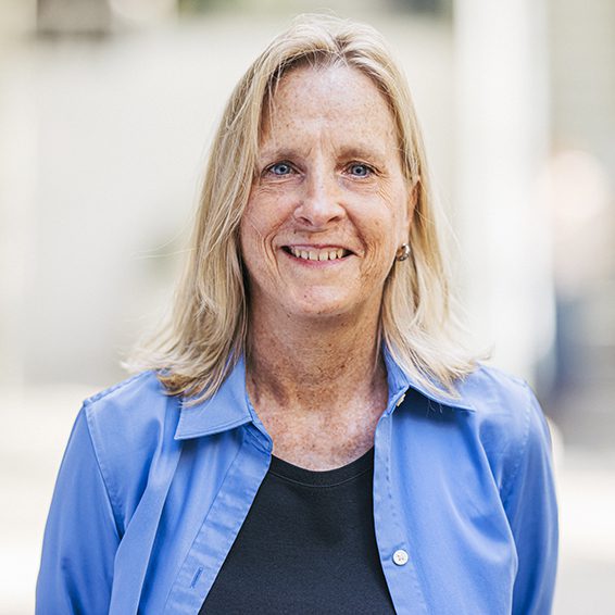 Mary Mingin Headshot. Mary is wearing a blue and black shirt.