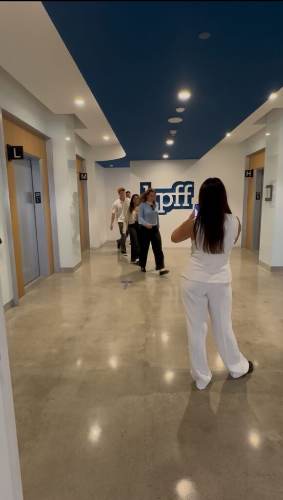 A marketing intern records interns for a social media post. 