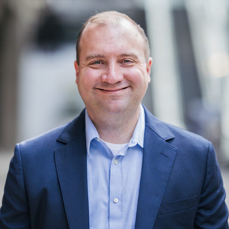 Man in a light blue shirt and a dark blue jacket